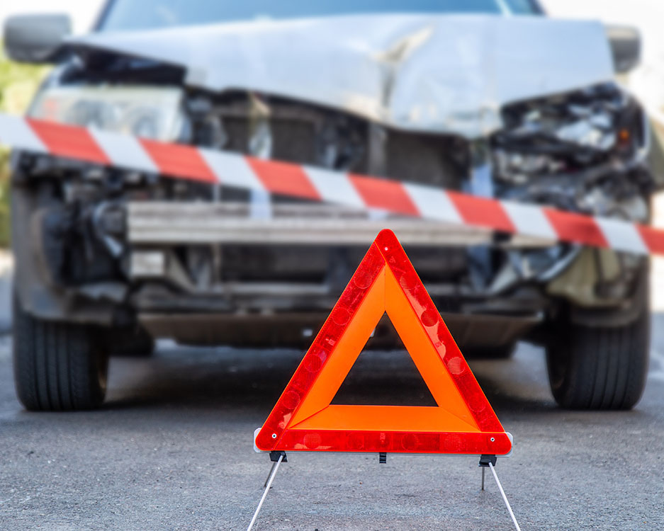 Unfall als Geschädigter – Unfallfahrzeug mit Warndreieck und Absperrband